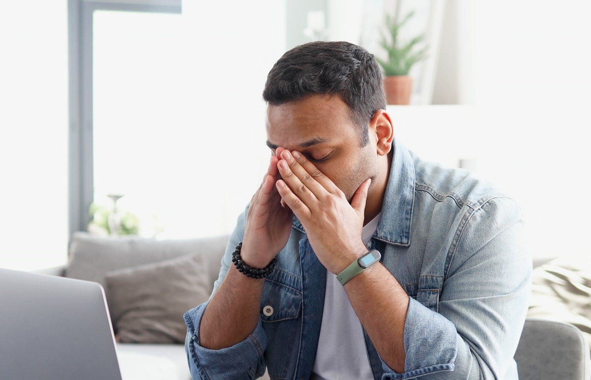 man looking uncomfortable while sitting in front of a computer