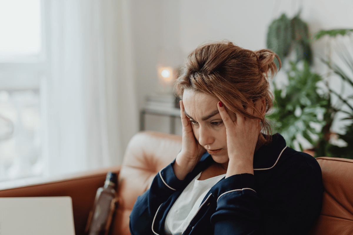 a woman holding her head and looking stressed
